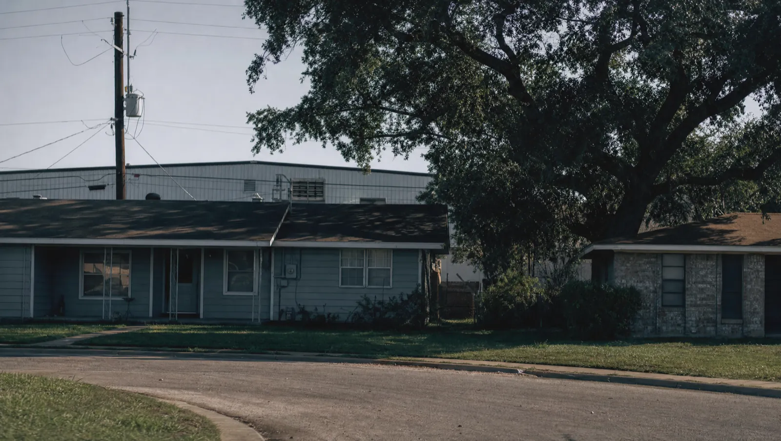 Single-storey homes with a warehouse roofline beyond in Bellmead, TX 76705, near I-35 and Loop 340